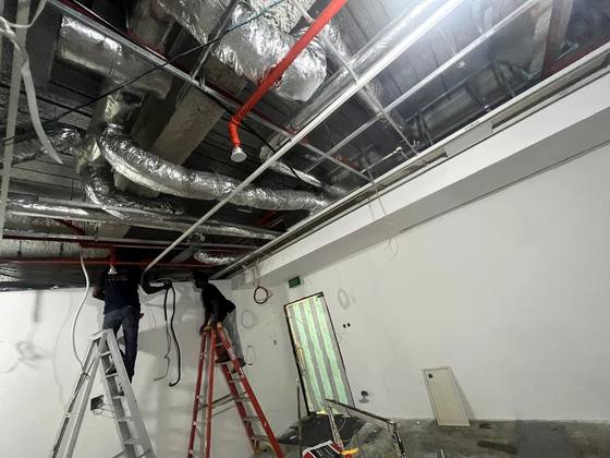 Installation team working in a live ceiling void